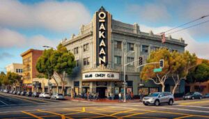 Exterior view of the Oakland Comedy Club during the day. The building has a distinct design with a prominent 'Oakland Comedy Club' sign. The 4